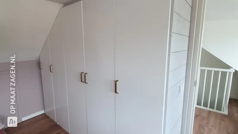 Op maat gemaakte kledingkast onder een schuin dak, door Marleen
