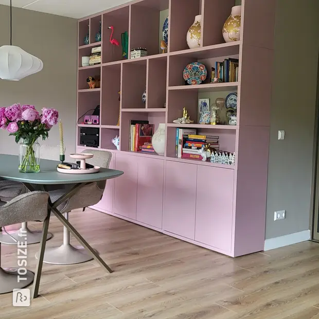 Meuble mural rose avec compartiments et portes ouverts