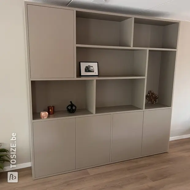 Beige kastenwand met open vakken en deuren