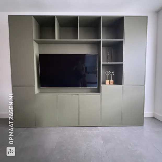 Green wall unit with open compartments and doors