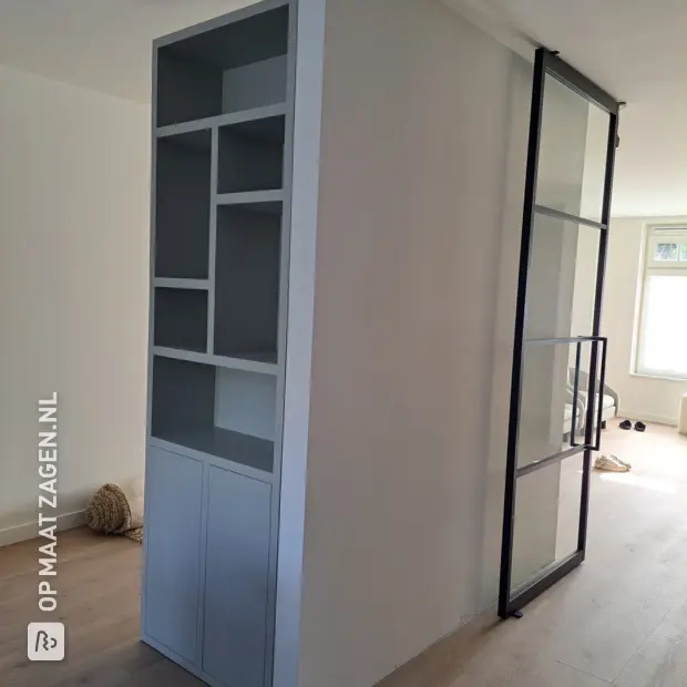 Grijze kastenwand met deuren en open vakken