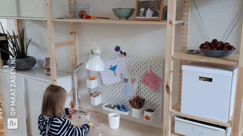 A children's desk between two cupboards