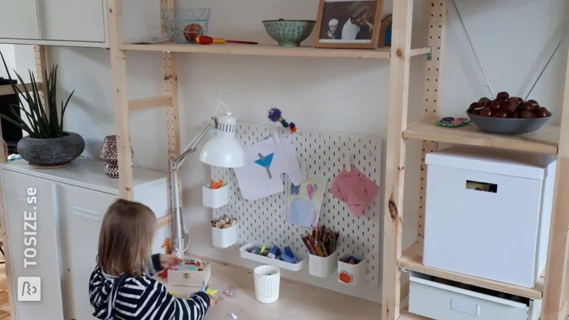 A children's desk between two cupboards