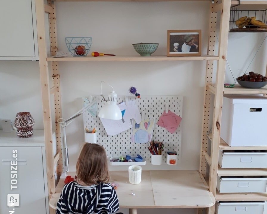 Un escritorio para niños entre dos armarios.