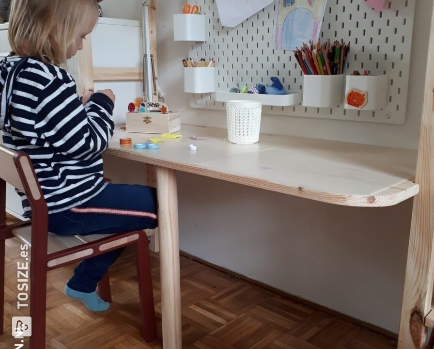 Un escritorio para niños entre dos armarios.