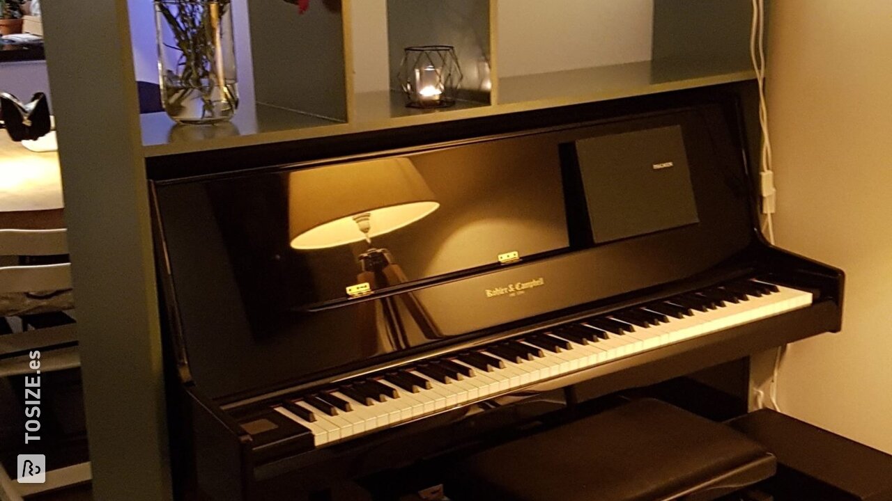 Separador de ambientes alrededor de un piano de MDF, por Koos