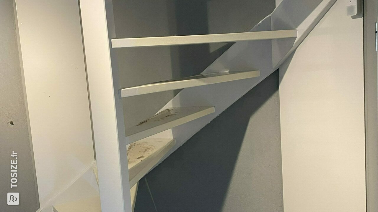 Fermeture d'un escalier ouvert avec du contreplaqué, par Martijn