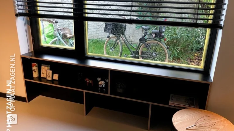 Een vensterbank met boekenkast
