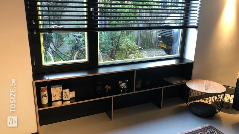 Een vensterbank met boekenkast