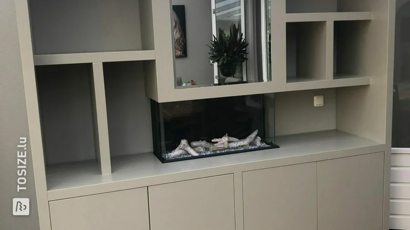 Compartment cupboard with built-in fireplace and mirror, by Ronnie