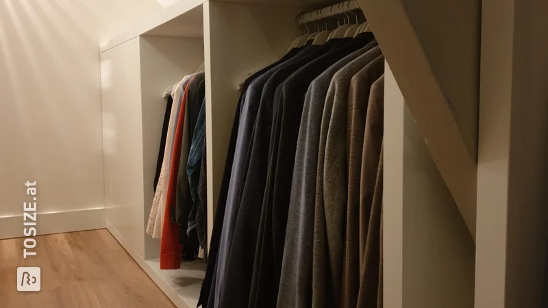 Ein begehbarer Kleiderschrank unter einer schrägen Wand von Evert