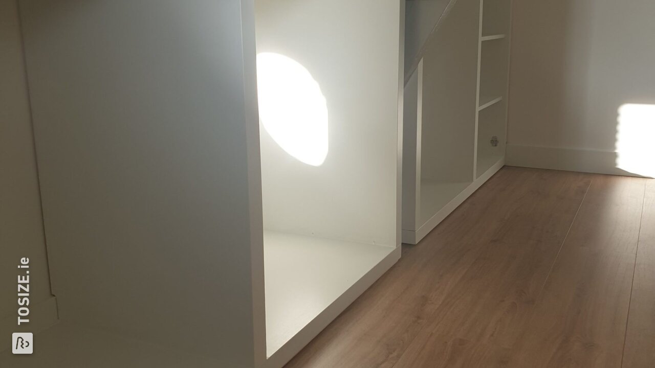 A walk-in closet under a sloping wall, by Evert