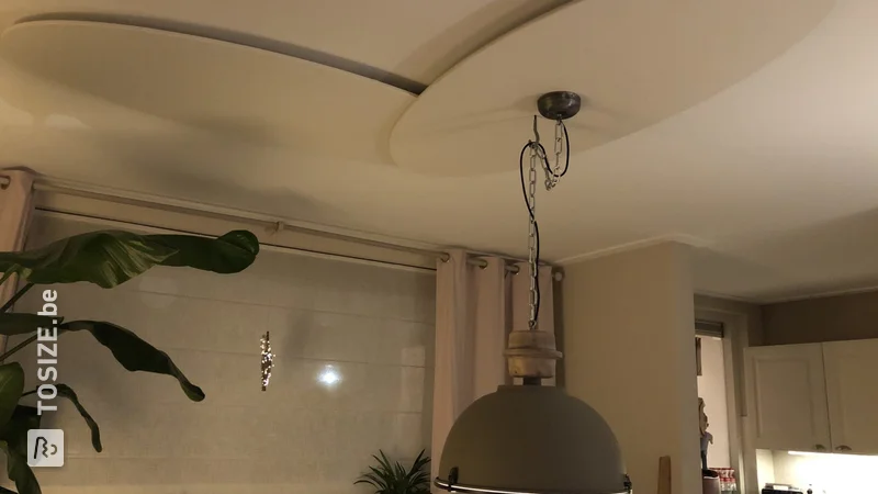 Montage d&#39;une lampe industrielle lourde sur un plafond en plâtre