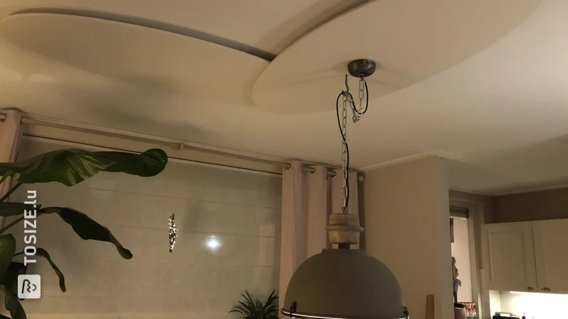 Montage d'une lampe industrielle lourde sur un plafond en plâtre