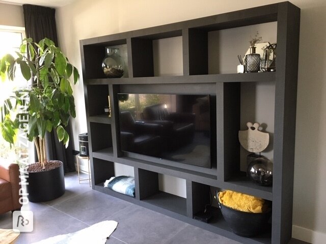 Een groot zwart TV-meubel op maat gemaakt, door Angela