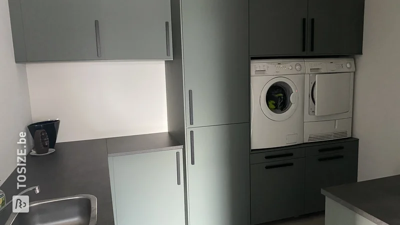 Washing machine and dryer raised in IKEA utility room, by Daan