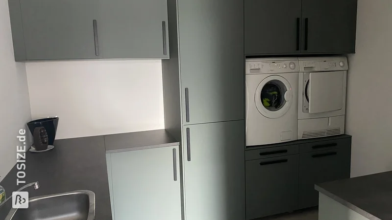 Washing machine and dryer raised in IKEA utility room, by Daan 