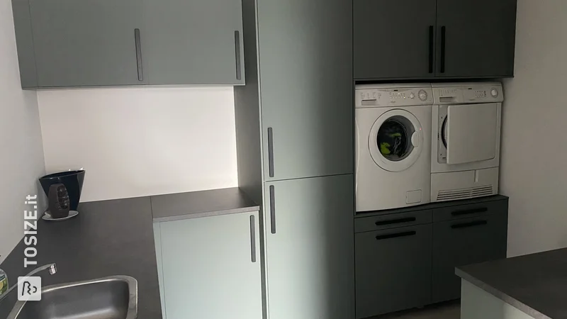 Washing machine and dryer raised in IKEA utility room, by Daan 