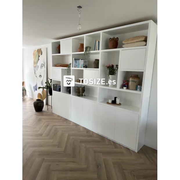 Armario de pared blanco con compartimentos y puertas abiertas