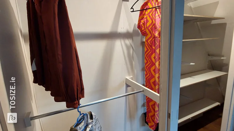 A homemade custom walk-in closet made of MDF for under the stairs, by Sanne