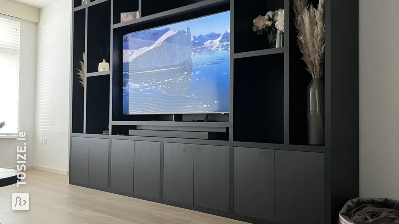A large custom TV cabinet in black oak, by Barry