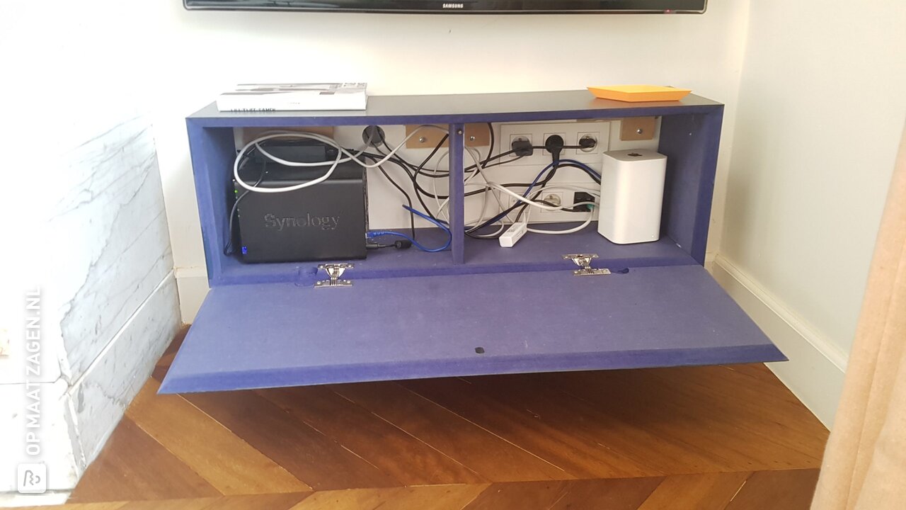 Een zwevend TV-kastje van blauw gekleurd MDF, door Freya
