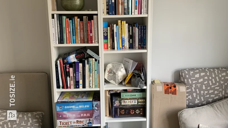 A homemade book wall made of shelves, by Tove