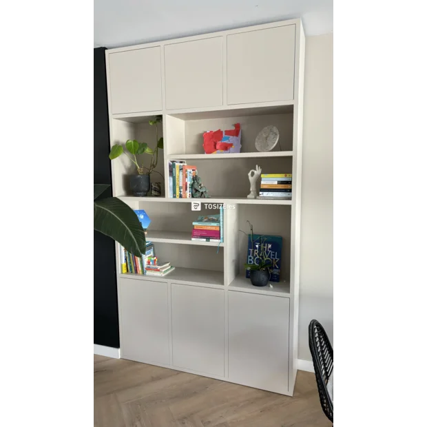 Mueble crema con puertas y compartimentos abiertos